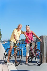 elderly-couple-on-bikes-by-ocean